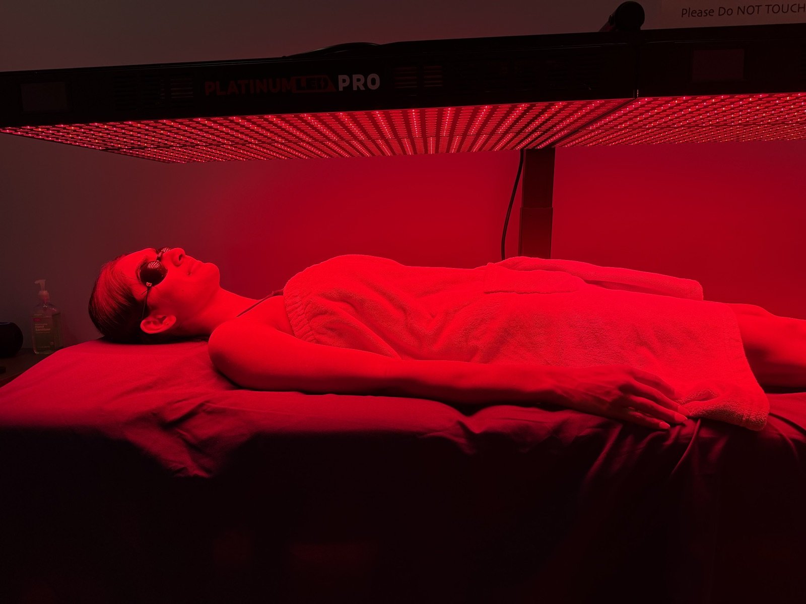 A client wearing protective goggles under the lit PlatinumLED PRO panels at Hydralive Huntersville