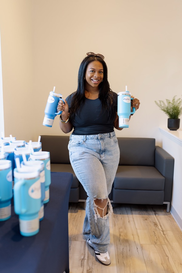A smiling client with Hydralive tumblers