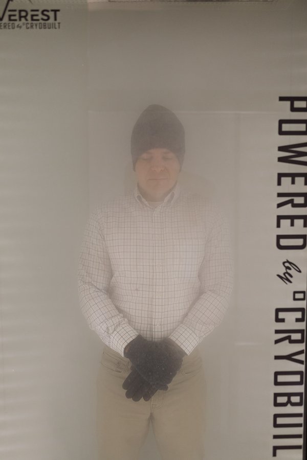A client inside the whole-body cryotherapy chamber surrounded by cold fog