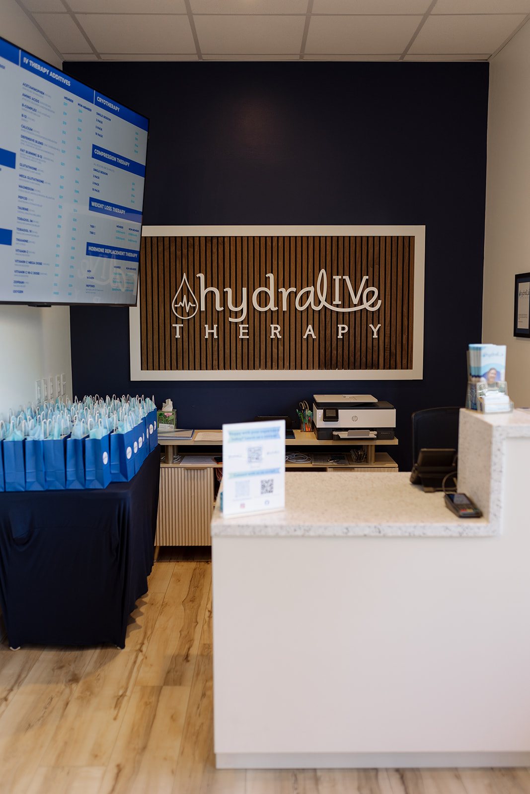 The front desk at Hydralive Huntersville with the wood Hydralive Therapy sign